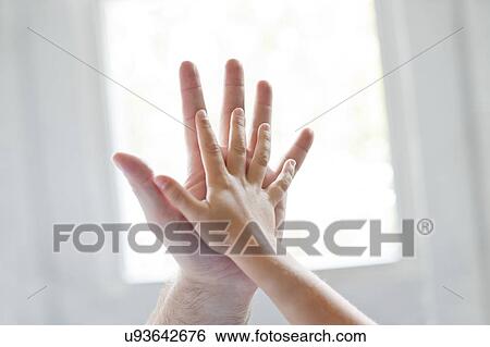 Stock Photograph - Child and adult touching hands.. Fotosearch