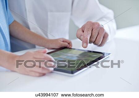 Stock Photo - Child and man using digital tablet, close up.. Fotosearch