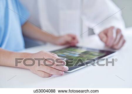 Stock Photo - Child and man using digital tablet, close up.. Fotosearch