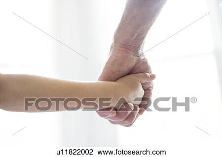 Stock Image - Child holding grandparent's hand.. Fotosearch