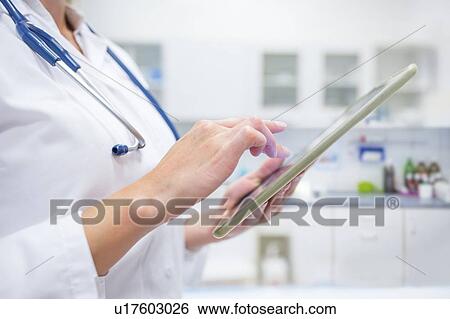 Cropped view of female doctor using digital tablet. View Large Photo Image Stock Photograph - Cropped view of female doctor using digital tablet.. Fotosearch