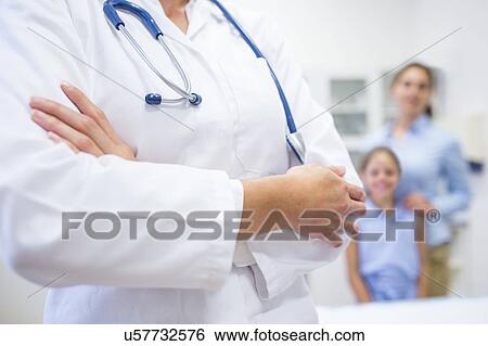Cropped view of female doctor with family in background. View Large Photo Image Stock Photograph - Cropped view of female doctor with family in background.. Fotosearch