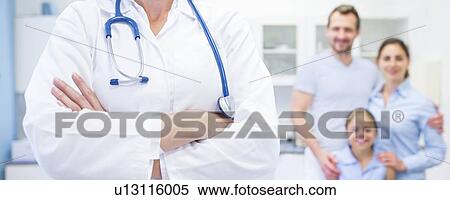 Stock Photography - Cropped view of female doctor with family in background.. Fotosearch
