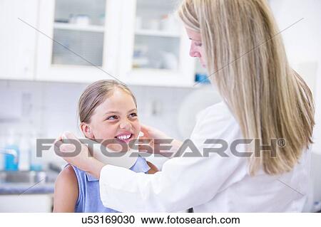 Doctor applying neck support to young girl. View Large Photo Image Stock Image - Doctor applying neck support to young girl.. Fotosearch