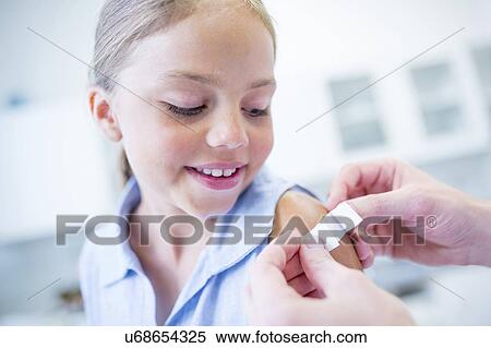Doctor applying plaster to child's arm after vaccination. View Large Photo Image Stock Photography - Doctor applying plaster to child's arm after vaccination.. Fotosearch