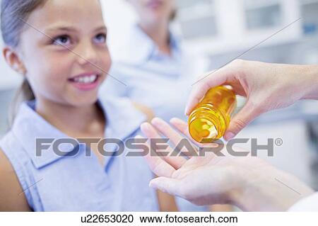 Doctor giving pills to young girl. View Large Photo Image Stock Image - Doctor giving pills to young girl.. Fotosearch