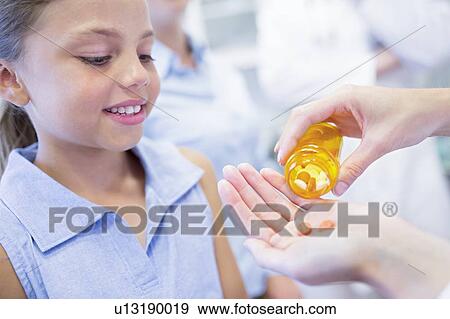 Doctor giving pills to young girl. View Large Photo Image Stock Photo - Doctor giving pills to young girl.. Fotosearch