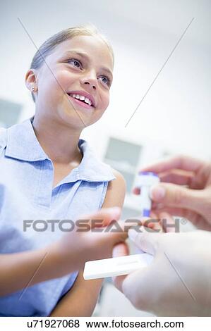 Doctor giving young girl a finger prick test. View Large Photo Image Stock Photo - Doctor giving young girl a finger prick test.. Fotosearch