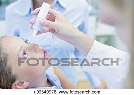 Doctor putting eye drops into young girl's eye. View Large Photo Image Stock Photo - Doctor putting eye drops into young girl's eye.. Fotosearch