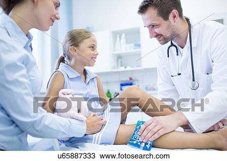 Doctor putting ice pack on young girl's leg. View Large Photo Image Stock Image - Doctor putting ice pack on young girl's leg.. Fotosearch