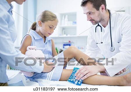 Doctor putting ice pack on young girl's leg. View Large Photo Image Stock Photo - Doctor putting ice pack on young girl's leg.. Fotosearch