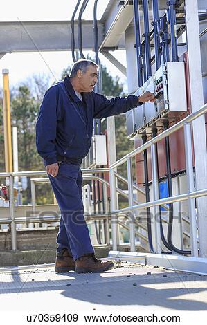 Stock Photo - Engineer at water treatment control panel.. Fotosearch
