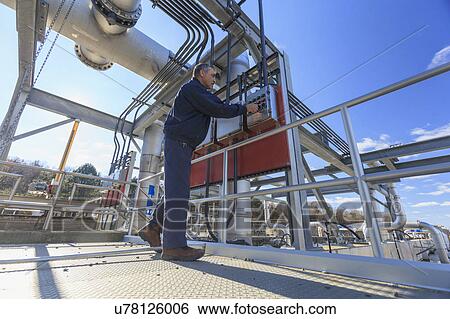 Stock Photograph - Engineer at water treatment outdoor control panel.. Fotosearch