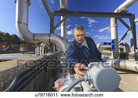Stock Image - Engineer examining sensor readout.. Fotosearch