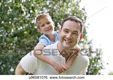 Father giving son piggy back. View Large Photo Image Stock Photograph - Father giving son piggy back.. Fotosearch