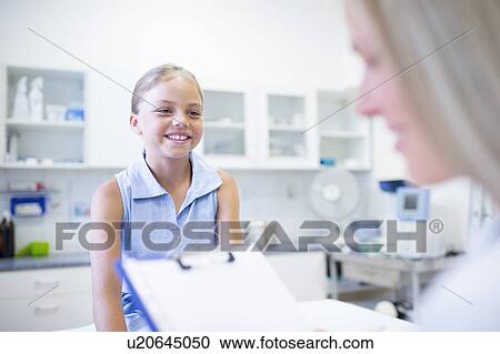 Female doctor examining young girl. View Large Photo Image Stock Image - Female doctor examining young girl.. Fotosearch