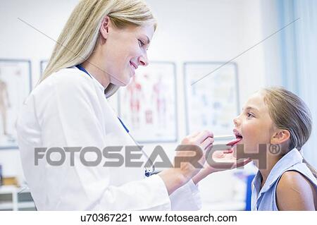 Stock Image - Female doctor examining young girl.. Fotosearch