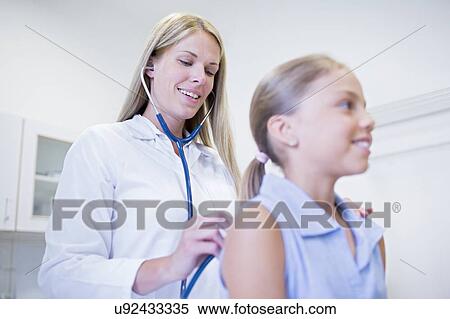 Female doctor examining young girl. View Large Photo Image Stock Photography - Female doctor examining young girl.. Fotosearch