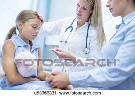 Stock Image - Female doctor taking girl's temperature.. Fotosearch