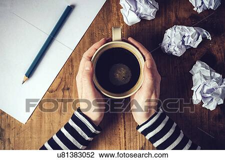 Stock Image - Female writer drinking cup of coffee. Fotosearch