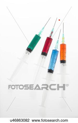 Stock Image - Four syringes with colourful liquid, studio shot.. Fotosearch