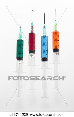 Stock Photo - Four syringes with colourful liquid, studio shot.. Fotosearch