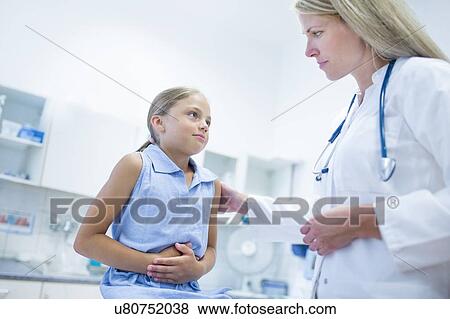 Stock Photo - Girl clutching tummy, doctor with hand on her shoulder.. Fotosearch