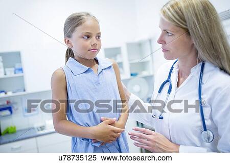 Stock Photography - Girl clutching tummy, doctor with hand on her shoulder.. Fotosearch