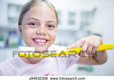 Girl holding oversized toothbrush. View Large Photo Image Stock Photograph - Girl holding oversized toothbrush.. Fotosearch