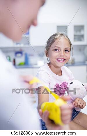 Stock Photography - Girl with arm brace holding teddy bear.. Fotosearch