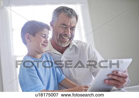 Grandfather and grandson using digital tablet. View Large Photo Image Stock Photo - Grandfather and grandson using digital tablet.. Fotosearch