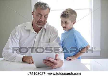 Grandfather and grandson using digital tablet. View Large Photo Image Stock Photo - Grandfather and grandson using digital tablet.. Fotosearch
