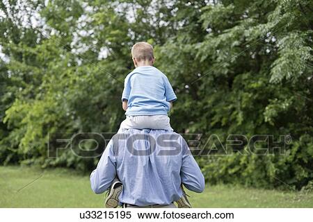 Grandfather carrying grandson on shoulders, rear view. View Large Photo Image Stock Photography - Grandfather carrying grandson on shoulders, rear view.. Fotosearch