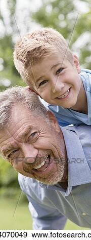 Stock Photo - Grandfather giving grandson a piggy back.. Fotosearch