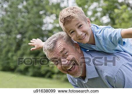 Grandfather giving grandson a piggy back. View Large Photo Image Stock Photo - Grandfather giving grandson a piggy back.. Fotosearch