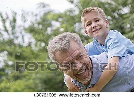 Grandfather giving grandson a piggy back. View Large Photo Image Stock Photography - Grandfather giving grandson a piggy back.. Fotosearch