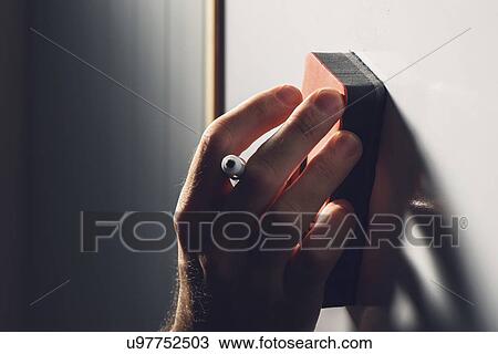 Stock Image - Hand wiping whiteboard. Fotosearch
