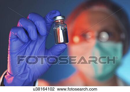 Healthcare worker with vaccine bottle View Large Photo Image Stock Image - Healthcare worker with vaccine bottle. Fotosearch