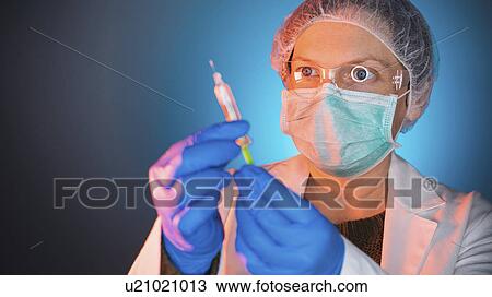 Stock Image - Healthcare worker with vaccine syringe. Fotosearch