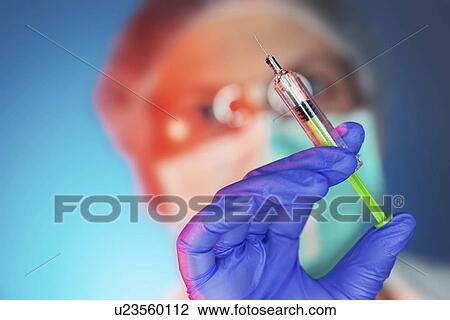 Stock Image - Healthcare worker with vaccine syringe. Fotosearch