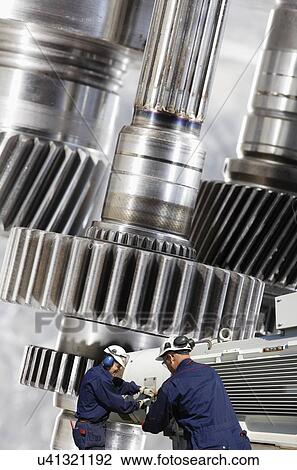 Industrial workers with large gear shafts and cogs. View Large Photo Image Stock Image - Industrial workers with large gear shafts and cogs.. Fotosearch