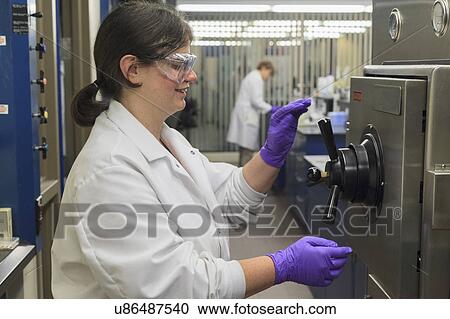 Stock Image - Lab technician opening sterilization tank.. Fotosearch