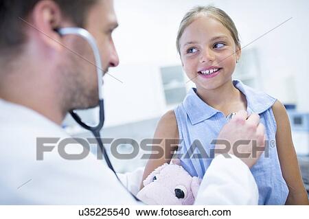 Male doctor examining young girl. View Large Photo Image Stock Image - Male doctor examining young girl.. Fotosearch