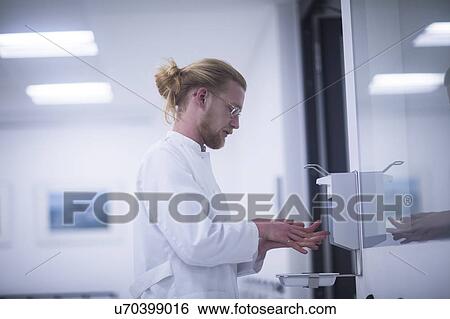 Stock Photograph - Male doctor using hand sanitiser. Fotosearch