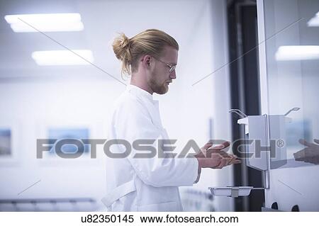 Male doctor using hand sanitiser View Large Photo Image Stock Photography - Male doctor using hand sanitiser. Fotosearch