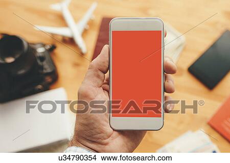 Picture - Male hand holding smartphone. Fotosearch