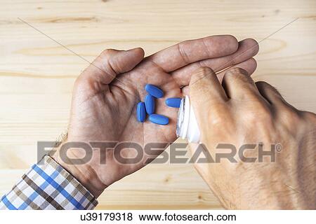 Man taking blue pills View Large Photo Image Stock Photo - Man taking blue pills. Fotosearch