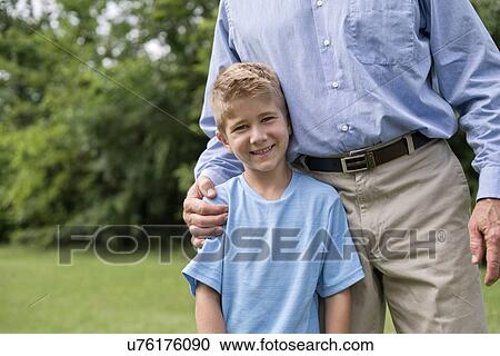 Man with arm around young boy, smiling. View Large Photo Image Stock Image - Man with arm around young boy, smiling.. Fotosearch