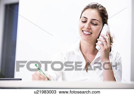 Stock Image - Medical receptionist on the telephone.. Fotosearch