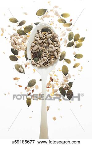 Stock Photo - Mixed seeds on spoon, studio shot.. Fotosearch